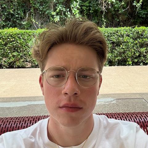 Dylan Ryfe taking a selfie on a bench in glasses