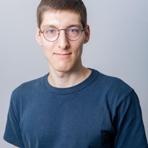 Headshot of William Donnelly in glasses and a blue tee shirt